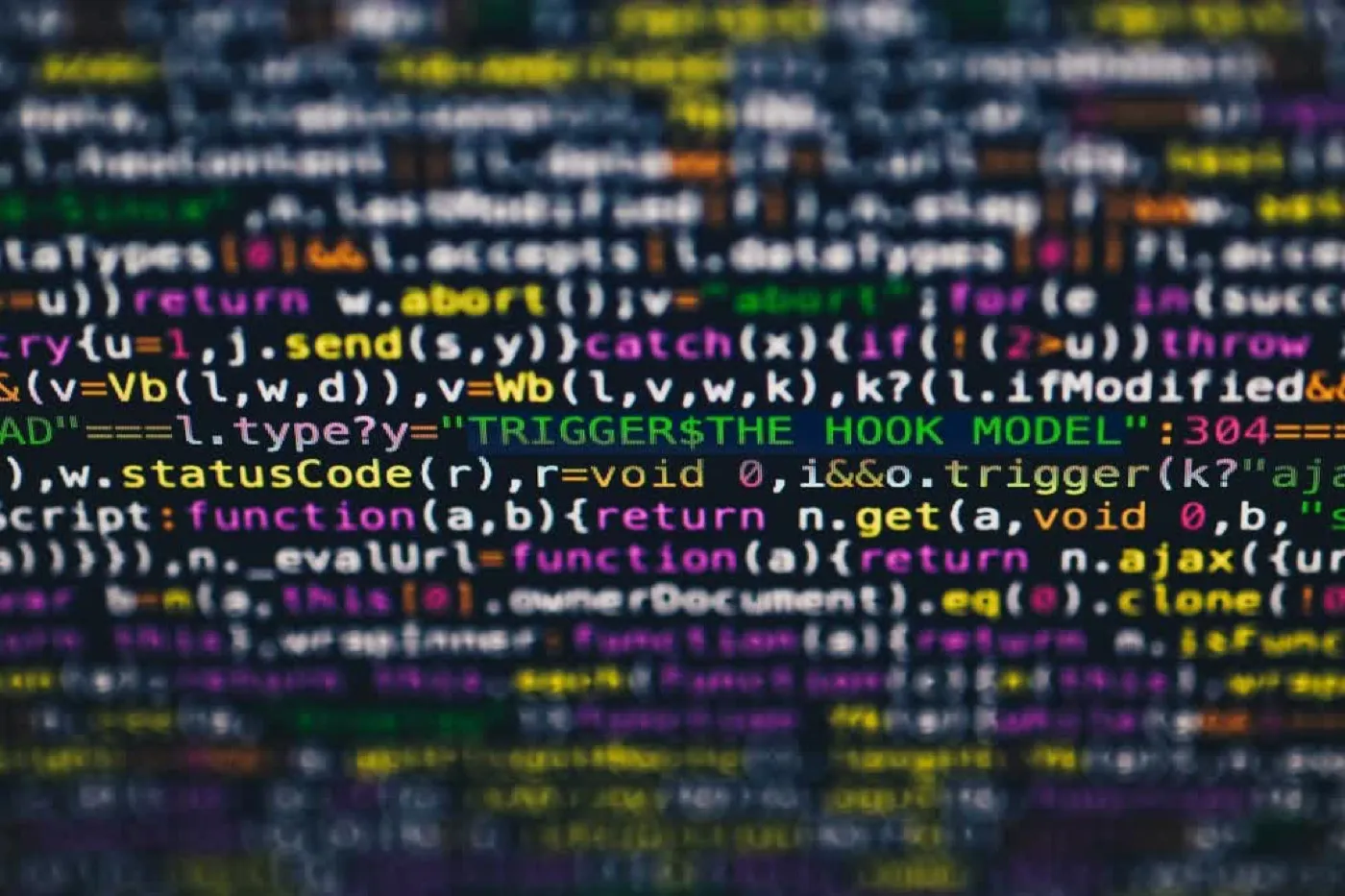 Unscharfe Nahaufnahme von farbig hervorgehobenem Quellcode auf dunklem Hintergrund.